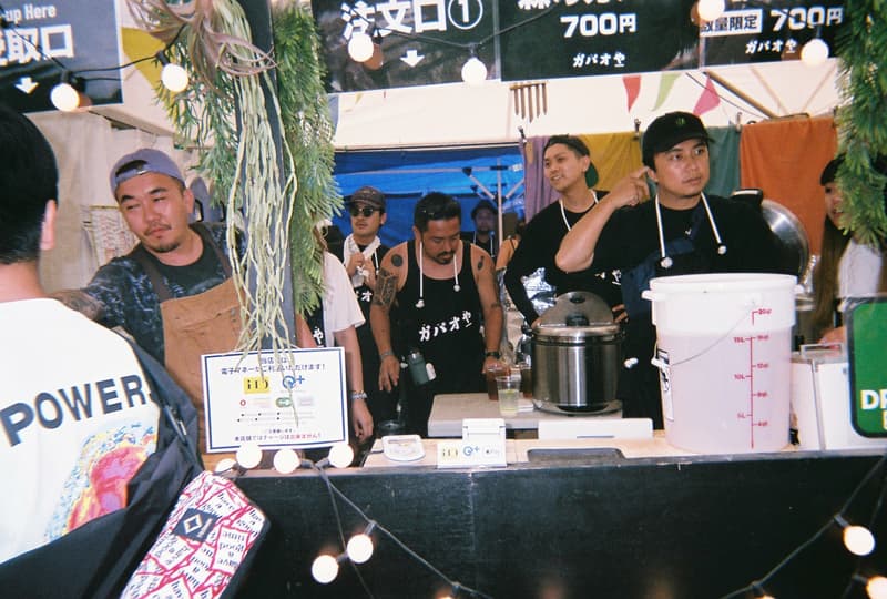 Back to Film:HYPEBEAST 編集部の等身大 FUJI ROCK FESTIVAL '18 備忘録 ファッション業界の方々から学生時代の部活の先輩まで、『HYPEBEAST』のリアルな日常を使い捨てカメラで記録した「FUJI ROCK」の番外編企画 山の天気は変わりやすい。「FUJI ROCK FESTIVAL '18」の会場となった苗場スキー場は途中に台風の通過もあってか、激しい雨と燦々と降り注ぐ日照りの繰り返しで、どこかの先人が作った言葉の意味を再認識した3日間だった。『HYPEBEAST』では連日、臨場感溢れるアーティストのステージパフォーマンスを中心とした速報や、タフな環境下でもファッション>機能性のマインドを持ち合わせる人々を撮影したストリートスナップをご紹介してきた。これらの記事制作の背景に少しだけ触れると、取材は日中から場合によっては深夜にまで及び、翌日朝は写真の編集と記事の執筆、現場では聴きたいアーティストのライブを余裕綽々で堪能できる時間はほとんどなく、山道の移動と悪天候がプレゼントしてくれる疲労の蓄積で、夜はホテルに戻るや否や汗を流し、次の日に備えて寝る、これがリアルである。 しかし、移動の最中や束の間の休憩中に遭遇する、日頃からお世話になっているファッション/音楽業界の方々、夜遊び仲間、中学時代の部活の先輩、久しぶりに会った音好きの友人たちと言い合うライブの感想、たわいもない会話、そしてビールでの乾杯は、編集部にとっては紛れもない「FUJI ROCK」の醍醐味なのだ。 そこで、我々は本気の仕事の裏側で、ポケットに使い捨てカメラを忍ばせ、柵前の景色から美味しいご飯を提供してくれたお食事処の皆さんまで、実際にいたロケーションと遭遇した仕事仲間&友人を気の向くままにパシャパシャと撮影。このカジュアルな企画では、上原のセレクトショップ『UFO(UPPER FIELD ONE)』の千寿公久、過去に#Essentialsに登場してくれた『Mastered』編集長の三木系大、水原佑果や武居詩織&きなりのモデル勢など、レポート記事とストリートスナップには登場していない人の姿も収めることができた。暗かったり、写真の構図が雑だったり、ピントが合っていないのはご愛嬌。是非、『HYPEBEAST』編集部2名が緩めに切り取った「FUJI ROCK FESTIVAL '18」の等身大備忘録を上のフォトギャラリーから楽しんでみてほしい。 まだ「FUJI ROCK FESTIVAL '18」の初日、二日目、最終日のレポートとストリートスナップをチェックしていない方は、そちらもお見逃しなく。