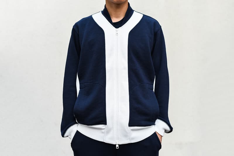 KIM JONES GU PRODUCTION ラストコレクションの一部アイテムを先行紹介 8月31日(金)の全商品ラインナップ発表に先駆け、『HYPEBEAST』編集部の元に到着した注目アイテムを緊急撮影 〈GU(ジーユー)〉がKim Jones(キム・ジョーンズ)とのコラボコレクション“KIM JONES GU PRODUCTION”のラストコレクションを発表してから間も無く、『HYPEBEAST』編集部の元に〈GU〉陣営から本コレクションの一部アイテムが到着した。 ティーザー画像にも登場するナバホブルゾンはポリエステル/レーヨン/ポリウレタンのボディで、ロゴ入りのダブルジップを採用し、後ろ身頃の裾はリブ状に。裏地も張られ、ブルゾンそのものに重量感があるため、冬場には高い防寒性を発揮してくれるだろう。また、チェック柄のマフラーはアクリル製のためにウールのようなチクチクとした肌触りを感じることがなく、表面には“KIM JONES”のロゴが配されている。また、左胸元に愛犬の刺繍パッチを施したスウェットフルジップパーカは、背中にも愛犬のモチーフをプリントすると同時に、その下には〈Dior(ディオール)〉のメンズデザイナーの名前をボディと同色の糸で立体的に刺繍。その他にはスエット生地のトラックジャケット&トラックパンツはネイビーにホワイトの切り替えが秀逸で、バックパックにはショルダーストラップに“KIM JONES”のロゴ入りテープをあしらい、フロントポケットに“AMERICA”のロゴがセットされている。 “KIM JONES GU PRODUCTION”のラストコレクションは9月14日(金)より発売開始となるが、全商品ラインナップは2018年8月31日(金)に特設ページにて公開されるとのこと。本コレクションのコンセプトについては、こちらからご確認を。