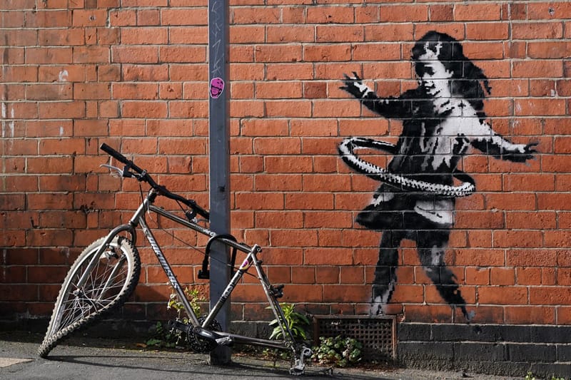 Banksy が英ノッティンガムに自転車のタイヤで遊ぶ少女を描く