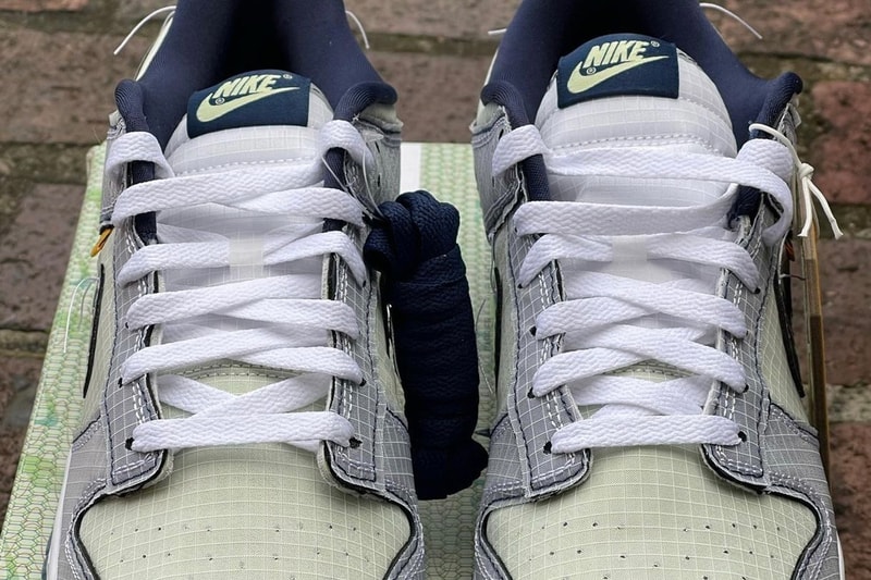 フライトにインスパイアされたユニオン x ナイキ ダンク ロー “Midnight Navy” のビジュアルが浮上 Detailed Look at the Union x Nike Dunk Low Midnight Navy First Look Release date info grid pattern frontman logo silver grey reflective flight tag baggage passport plane un la green mint blue