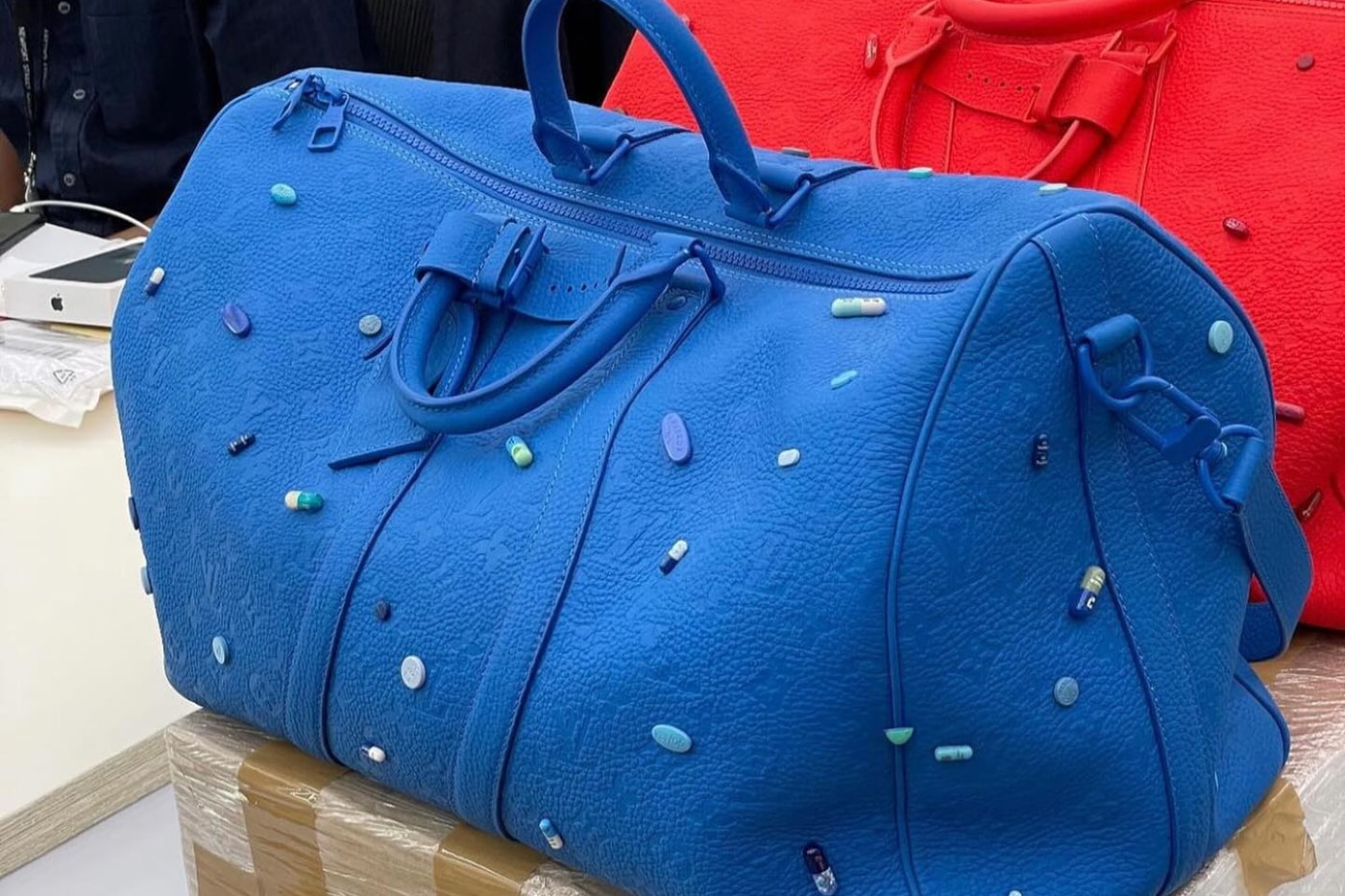ダミアンハーストとルイヴィトンが錠剤を装飾したコラボキーボルを発売？ First Look at the Rumored Damien Hirst x Louis Vuitton Keepall Bag pharrell williams menswear pills collaboration juxtaposition blue red 