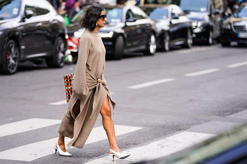 A guest wears sunglasses, earrings, a sand-color long sleeves knit dress slit on the sides, white pointy slingback heels, outside Giambattista Valli, during Paris Fashion Week - Womenswear Spring Summer 2020, on September 30, 2019 in Paris, France.