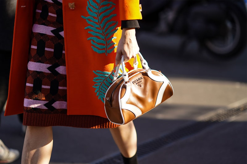 A guest wears a brown leather Prada bag, outside Prada, during Milan Fashion Week Fall/Winter 2020-2021 on February 20, 2020 in Milan, Italy.