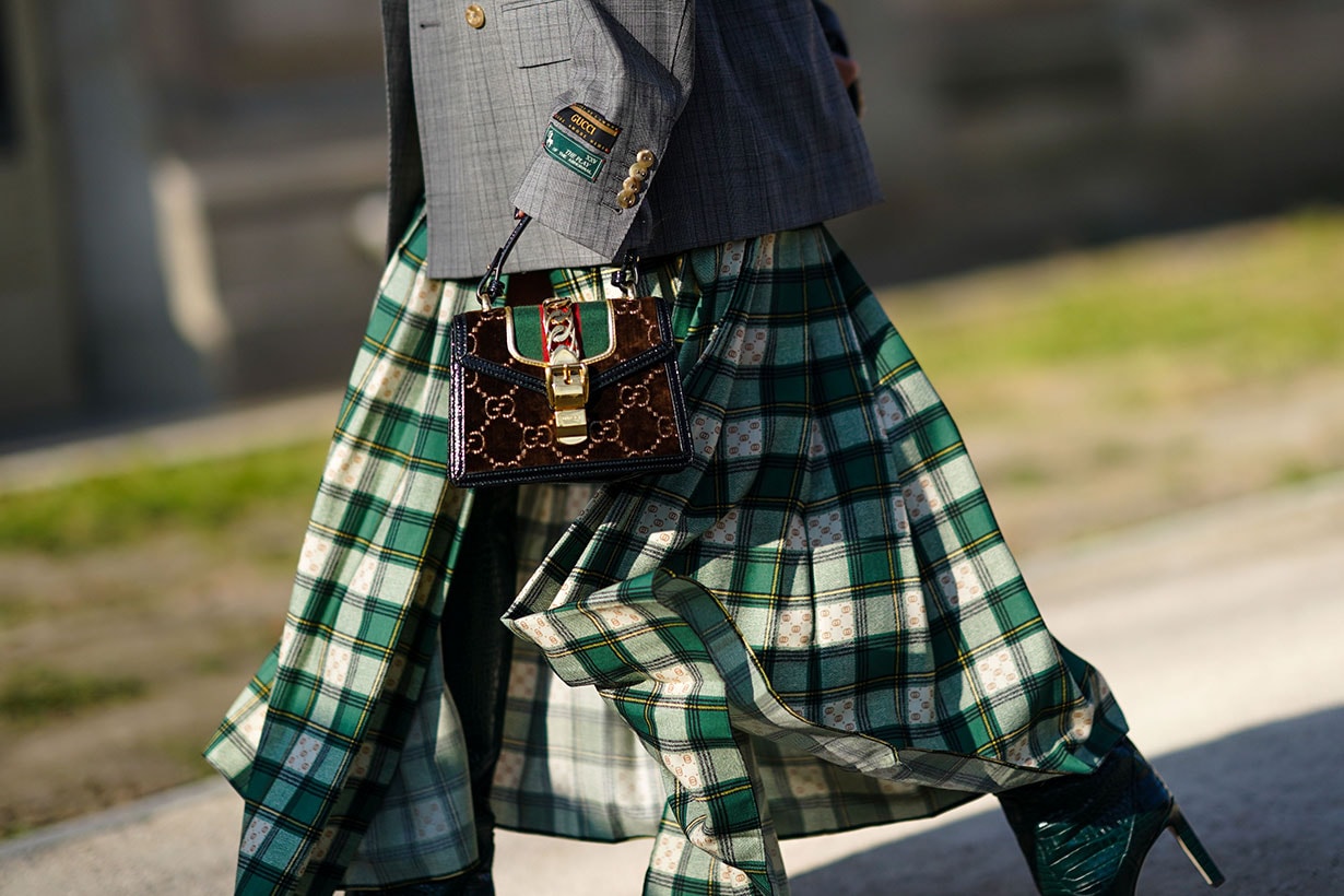 A guest wears a gray oversized blazer jacket, a Gucci bag, a green and white checked pleated skirt, outside Elie Saab, during Paris Fashion Week - Haute Couture Spring/Summer 2020, on January 22, 2020 in Paris, France.