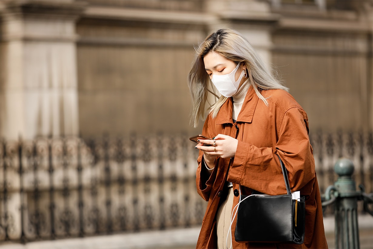 A guest wearing a face mask, tan orange trench outside Vivienne Westwood show during Paris Fashion week Womenswear Fall/Winter 2020/2021 Day Six on February 29, 2020 in Paris, France.