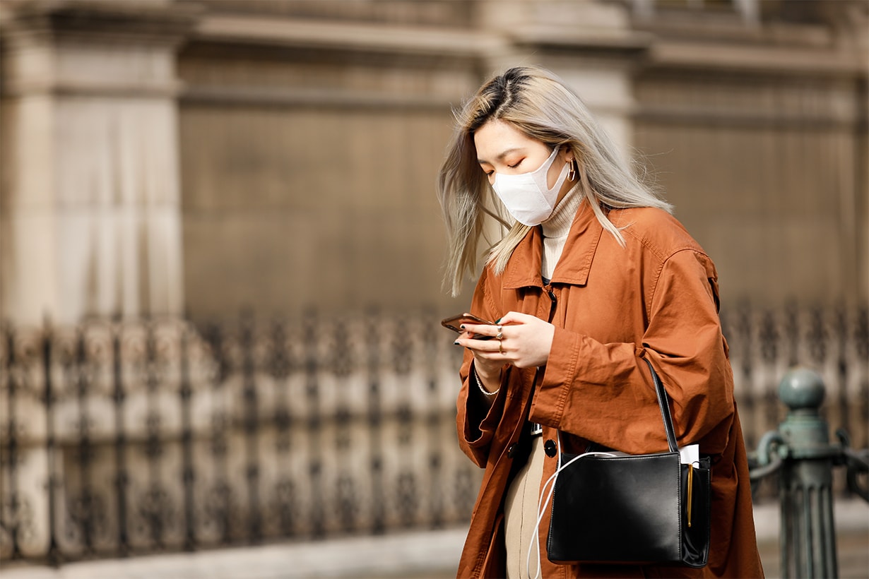 A guest wearing a face mask, tan orange trench outside Vivienne Westwood show during Paris Fashion week Womenswear Fall/Winter 2020/2021 Day Six on February 29, 2020 in Paris, France. 