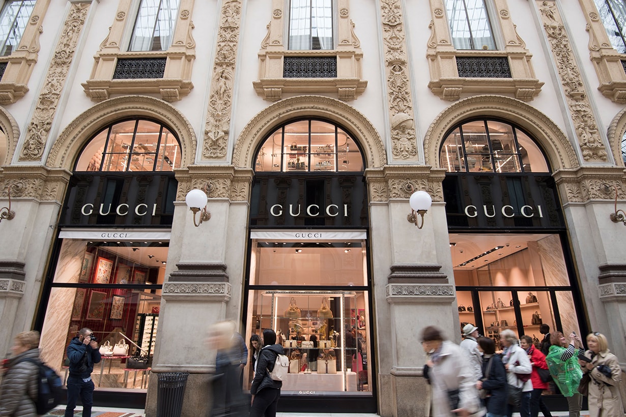 Tourists and Milanese walk past Italian fashion shop Gucci in the Vittorio Emanuele II luxury Gallery in the center of Milan on May 3, 2019. (Photo by Miguel MEDINA / AFP)