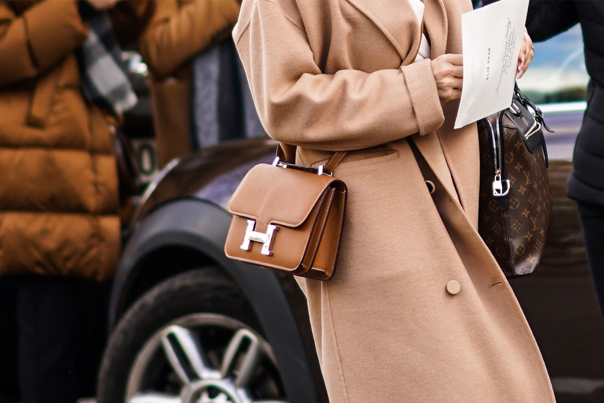 A guest wears a beige coat and a Hermes brown leather bag, outside Elie Saab, during Paris Fashion Week - Womenswear Fall/Winter 2020/2021, on February 29, 2020 in Paris, France.