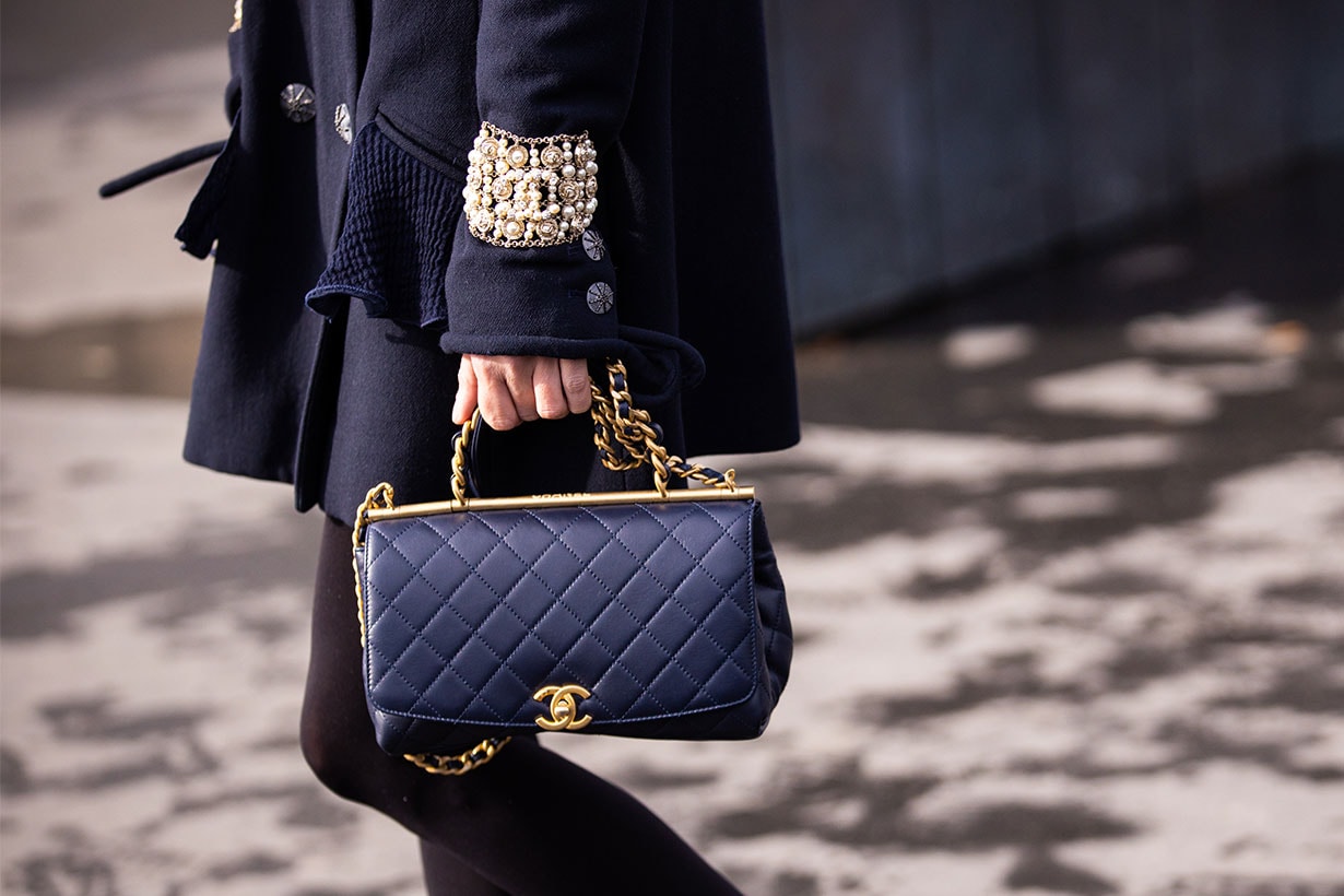 Chloe Harrouche, wearing a blue coat and blue Chanel bag, is seen outside Chanel, during Paris Fashion Week - Womenswear Fall/Winter 2020/2021 : Day Nine on March 03, 2020 in Paris, France.