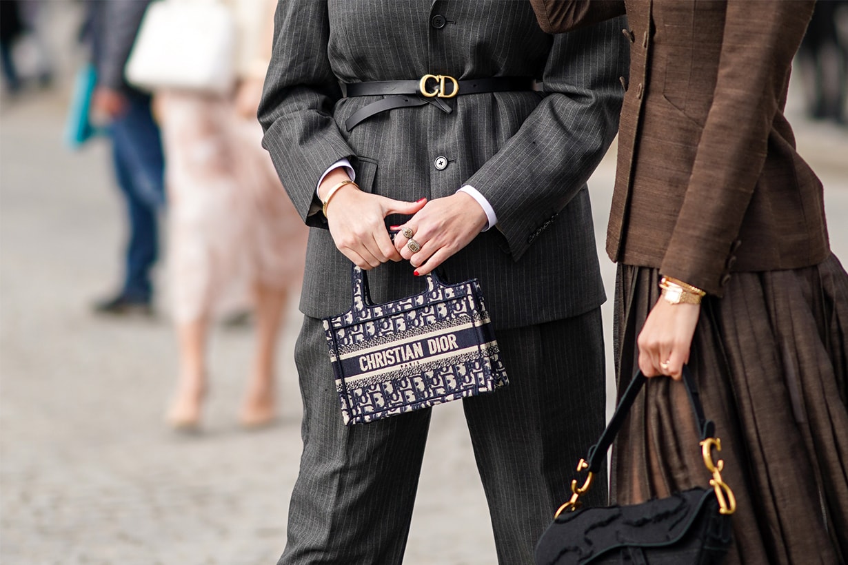 A guest wears a Dior mini shopping bag, a Dior belt, finger rings outside Dior, during Paris Fashion Week - Womenswear Fall/Winter 2020/2021, on February 25, 2020 in Paris, France