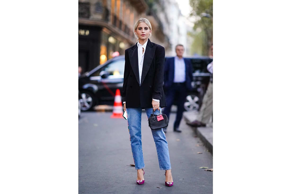  Caroline Daur wears a white shirt, a black blazer jacket, a bag with an attached pink mini bag, blue cropped jeans, purple shoes, outside Ralph Lauren, during Paris Fashion Week - Womenswear Spring Summer 2020 on September 28, 2019 in Paris, France. 
