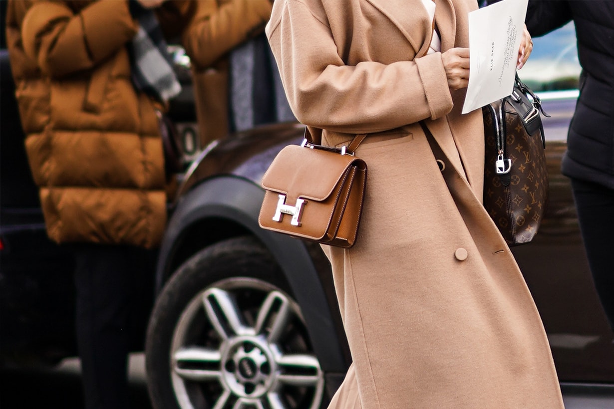 A guest wears a beige coat and a Hermes brown leather bag, outside Elie Saab, during Paris Fashion Week - Womenswear Fall/Winter 2020/2021, on February 29, 2020 in Paris, France. 