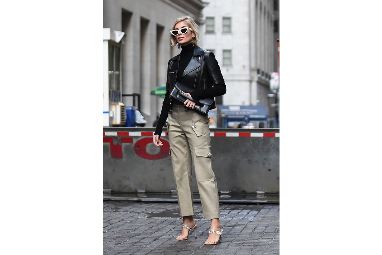 Xenia Adonts is seen wearing a black leather jacket, beige pants, black clutch and white sunglasses outside the Michael Kors show during New York Fashion Week: Fall/Winter 2019 on February 13, 2019 in New York City. 