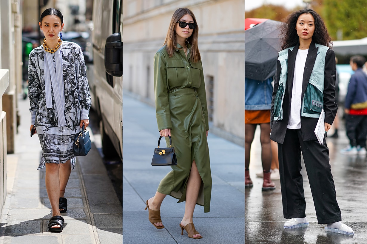 A guest wears one earring, a large gold-tone chain necklace, a black and white print dress with light blue striped cuffs and lavaliere, a navy blue handbag, black flat slides, outside JW Anderson, during Paris Fashion Week - Menswear Spring/Summer 2020, on June 19, 2019 in Paris, France.