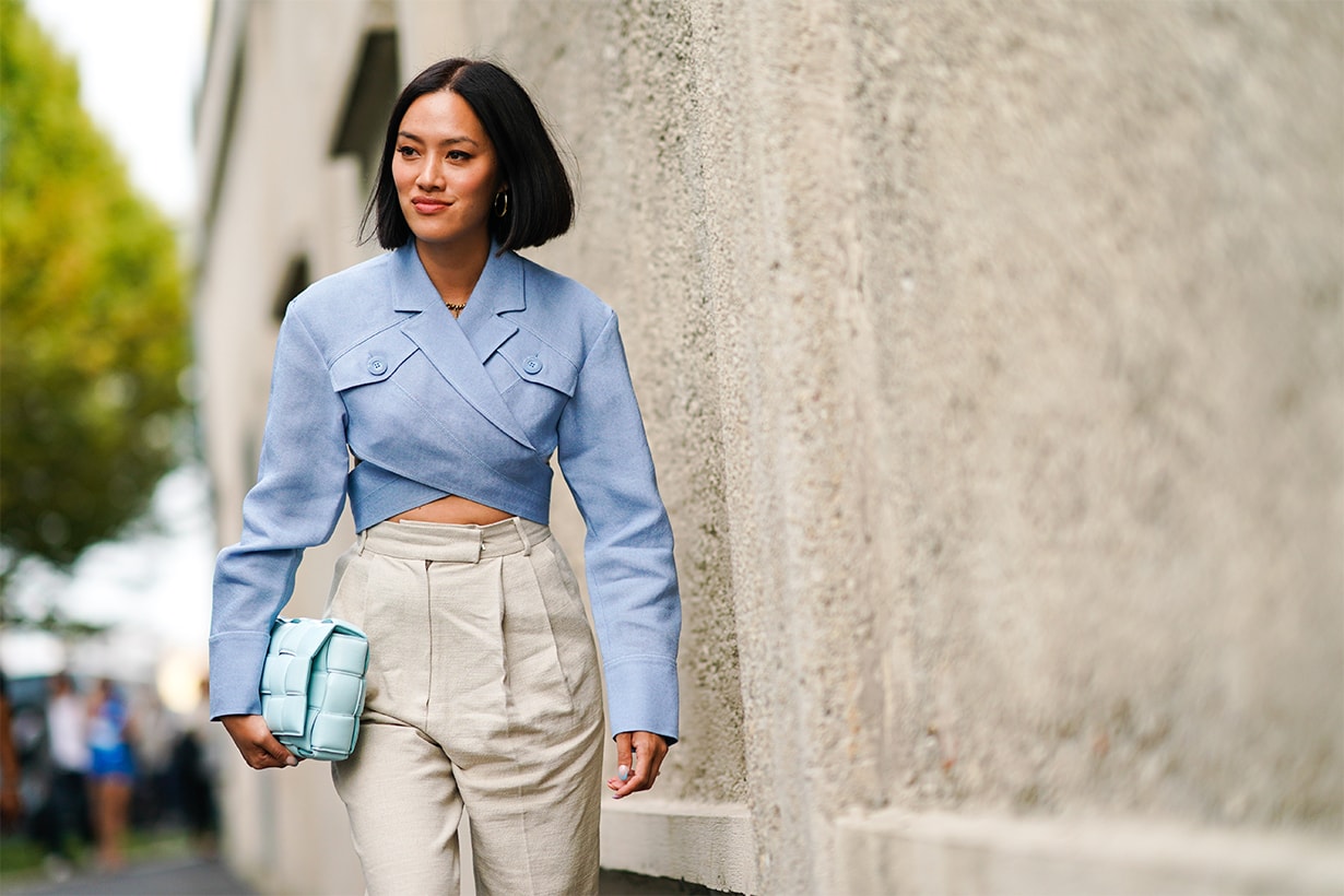 Tiffany Hsu wears a blue shirt, white pants, a pale green quilted bag, outside the Prada show during Milan Fashion Week Spring/Summer 2020 on September 18, 2019 in Milan, Italy.