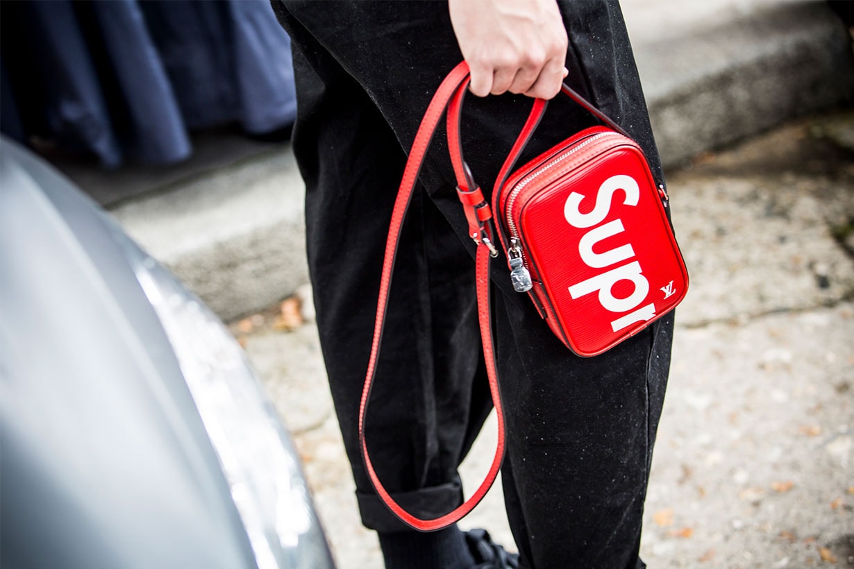 A guest poses with a Supreme bag before the Dior show at the Musee Rodin during Paris Fashion Week Womenswear SS18 on September 26, 2017 in Paris, France.