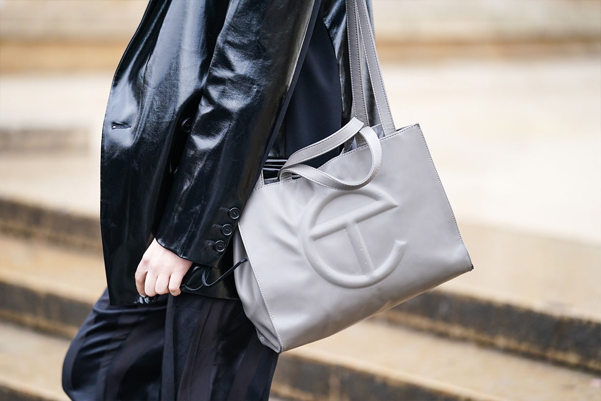 A guest wears a black leather jacket and a gray bag with a T logo, outside Ann Demeulemeester, during Paris Fashion Week - Womenswear Fall/Winter 2020/2021, on February 27, 2020 in Paris, France. 