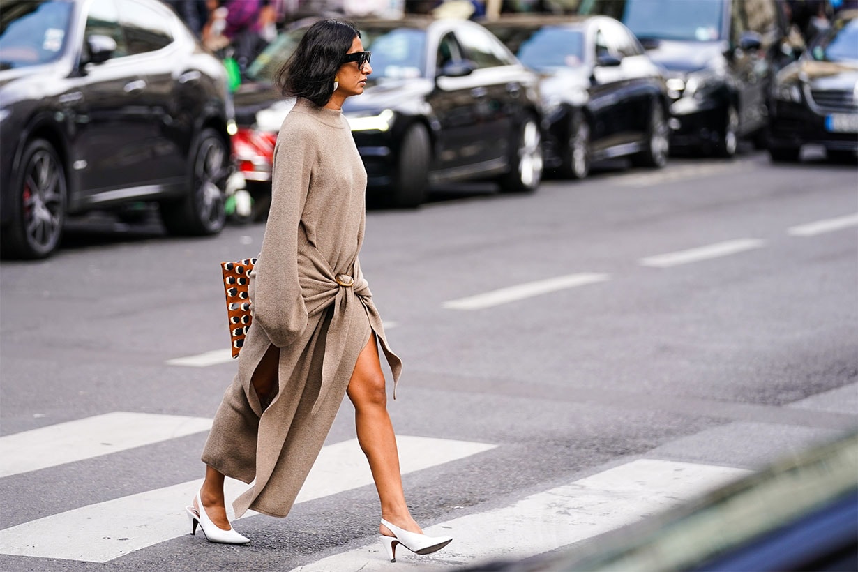 A guest wears sunglasses, earrings, a sand-color long sleeves knit dress slit on the sides, white pointy slingback heels, outside Giambattista Valli, during Paris Fashion Week - Womenswear Spring Summer 2020, on September 30, 2019 in Paris, France. 