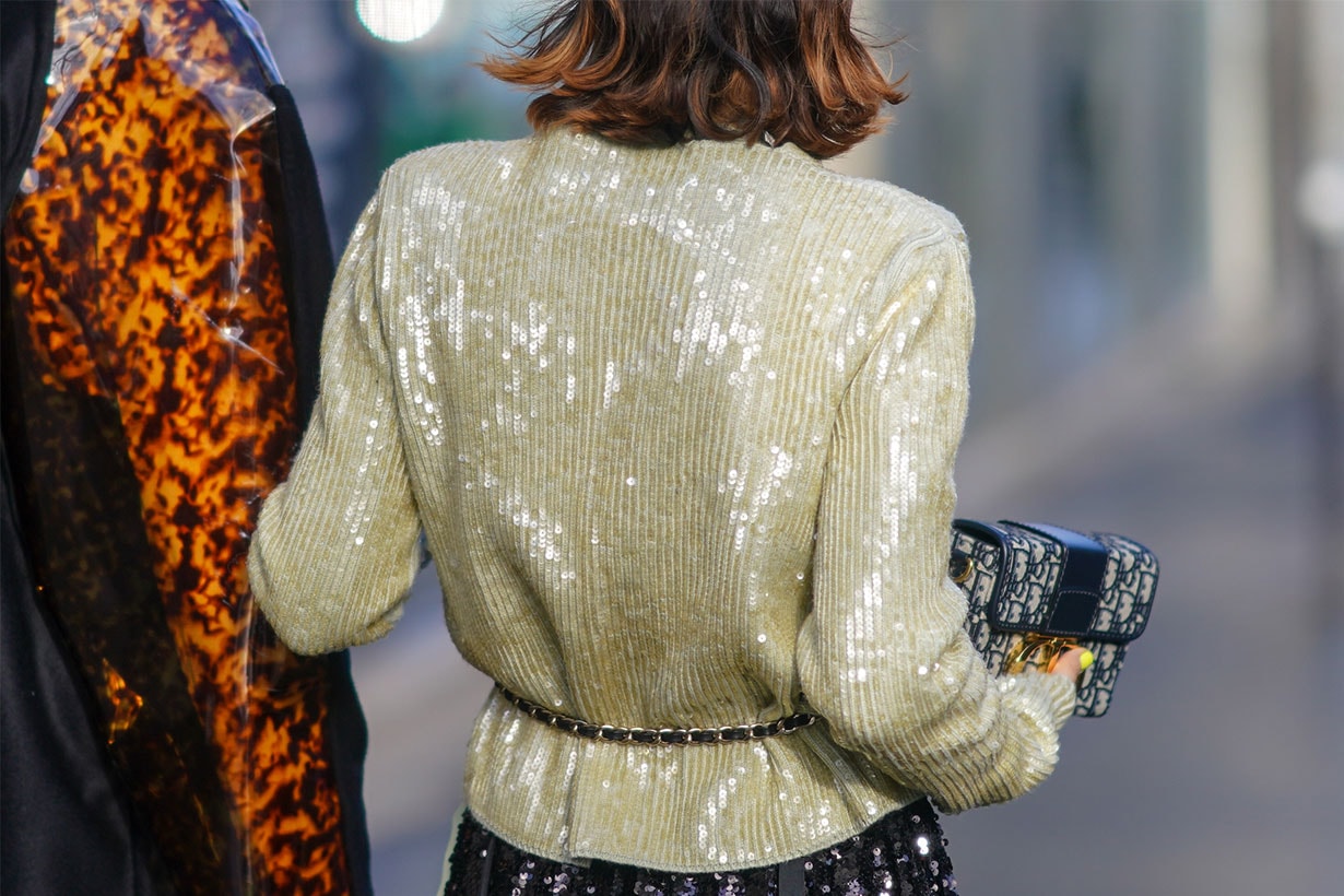 A guest wears a glittering pale yellow sequined jacket, a glittering black sequined skirt, a Christian Dior monogram clutch, outside Lanvin, during Paris Fashion Week - Womenswear Fall/Winter 2020/2021, on February 26, 2020 in Paris, France.