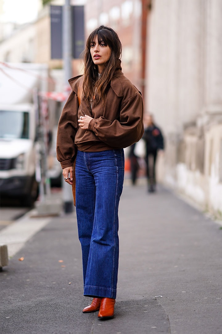Louise Follain wears a brown jacket, a white top, blue denim jeans, brown leather shoes, outside Koche x Pucci, during Milan Fashion Week Fall/Winter 2020-2021 on February 20, 2020 in Milan, Italy.