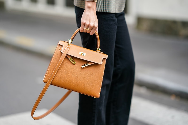 May Berthelot wears finger rings, a brown leather Hermes bag, black pants, outside the unveilling of the Longchamp collection Spring/Summer 2021, during Paris Fashion Week - Womenswear Spring Summer 2021, on October 04, 2020 in Paris, France.
