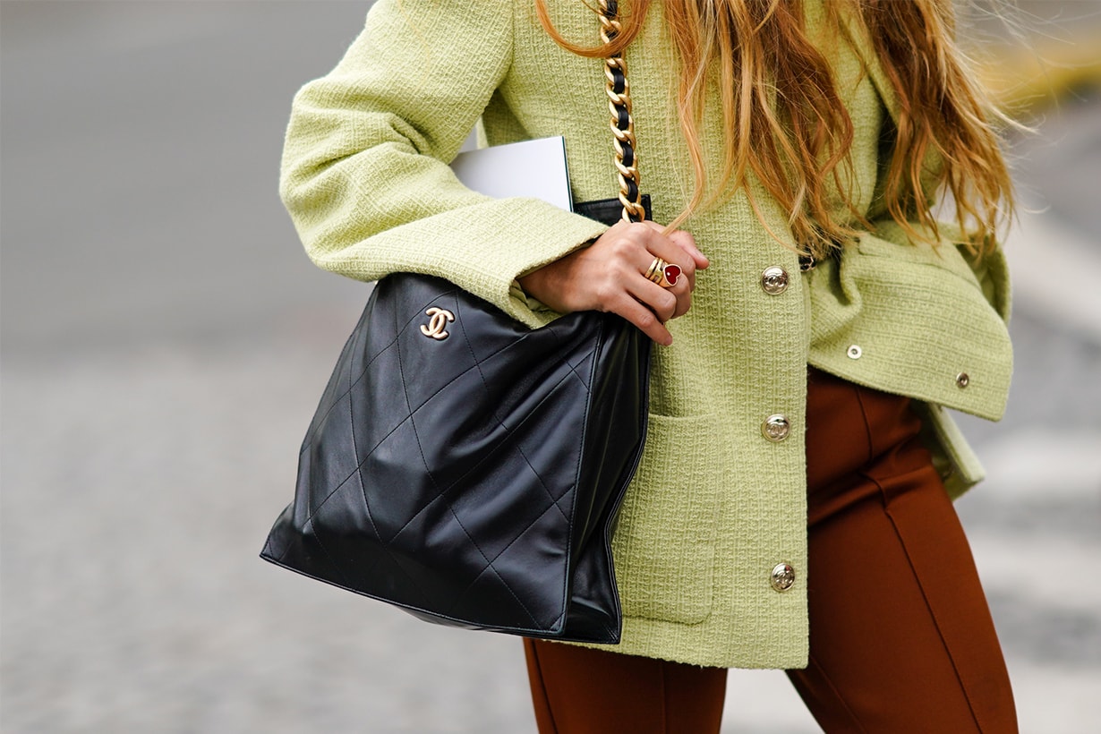 Blanca Miro wears a pale green tweed jacket with silver metallic buttons, a black leather Chanel bag, brown pants, outside Chanel, during Paris Fashion Week - Womenswear Spring Summer 2021, on October 06, 2020 in Paris, France.