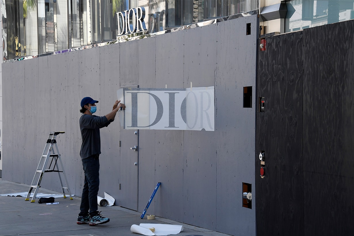 A worker places a sign on boarded up Dior store on Rodeo Drive in Beverly Hills, California, closed for pedestrian and vehicular traffic in preparation for possible unrest on the night of U.S. presidential election on November 3, 2020 in Beverly Hills, California. Businesses in cities across the country are preparing for possible unrest as election results come in.