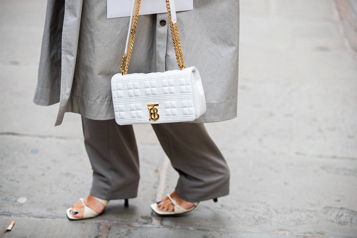 Beatrice Gutu wearing grey trench coat, pants, white Burberry bag, sandals is seen outside Erdem during London Fashion Week September 2019 on September 16, 2019 in London, England.