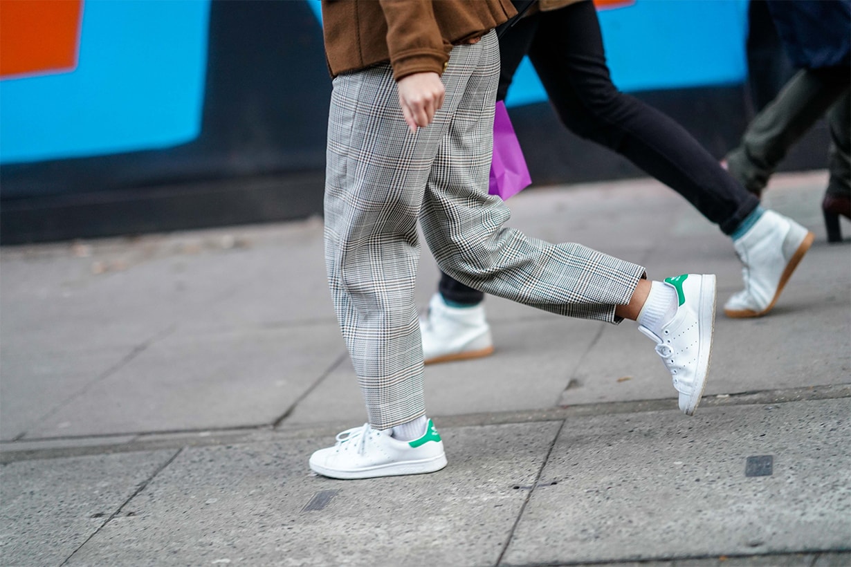 A guest wears Adidas Stan Smith sneakers shoes, gray pants, during London Fashion Week Men's January 2018 at on January 6, 2018 in London, England.