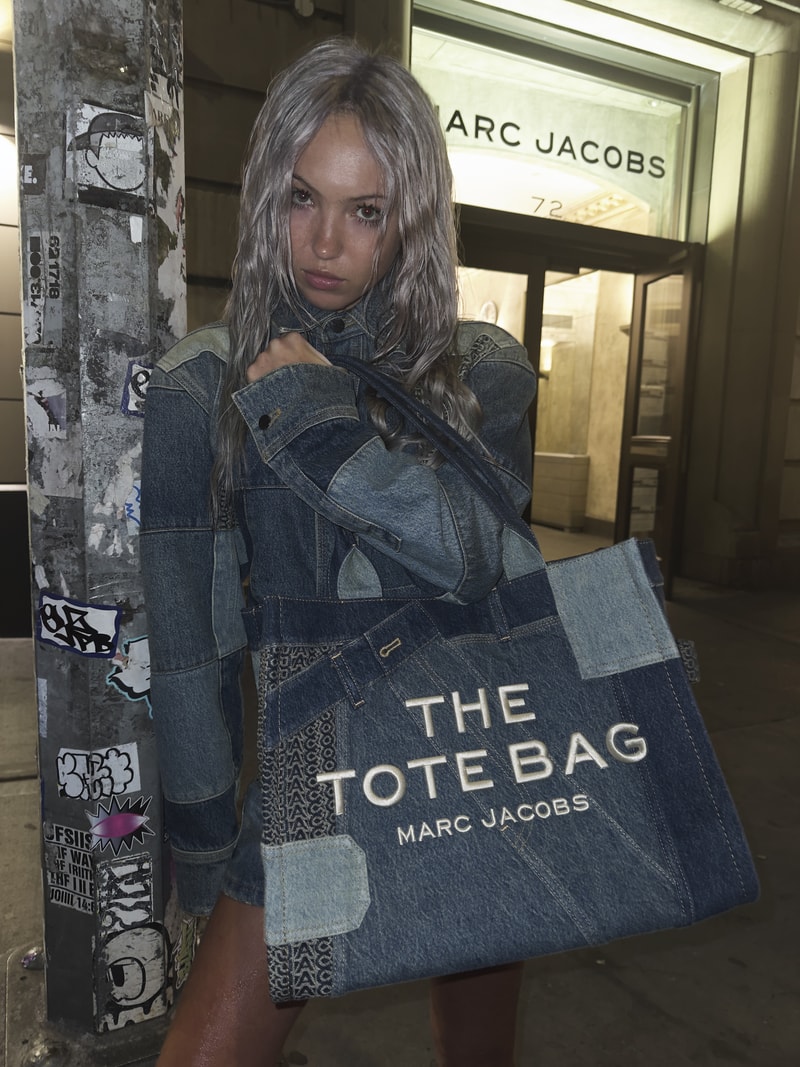 Black Marc Jacobs The Tote Bag photographed in a luxury city setting.