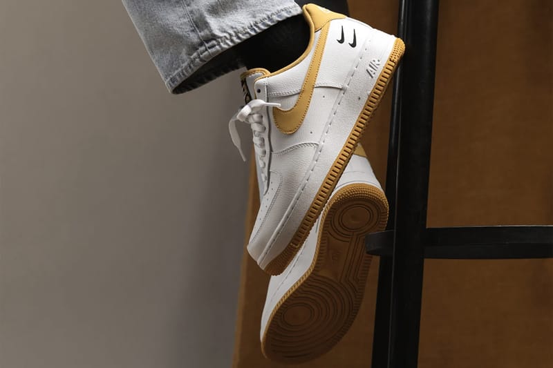 Nike white best sale with gold swoosh