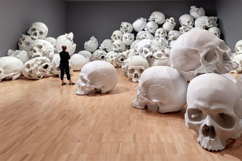 ロン・ミュエクによる100体の巨大頭蓋骨が積まれたインスタレーション