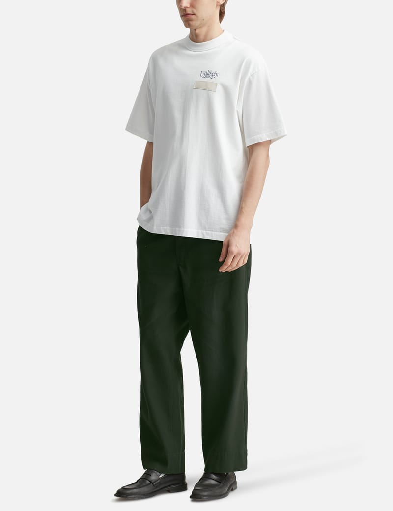 Unlikely Unlikely Team Tee - 日本製のルーズフィット半袖T。胸ロゴ